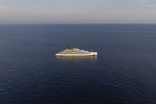 Aerial view of a sleek luxury yacht cruising through the deep blue waters of the Tyrrhenian Sea near the coast, Amalfi, Amalfi Coast, Italy.