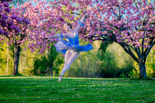 Ballerina jumping gracefully outdoors