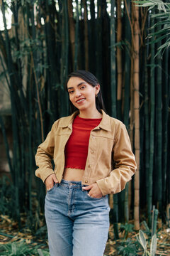 Pretty girl with slightly bent pose and hands in pockets.
