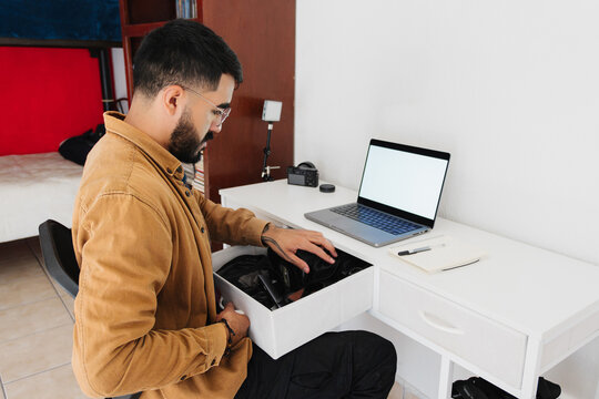 A photographer looking for things in his desk drawer.