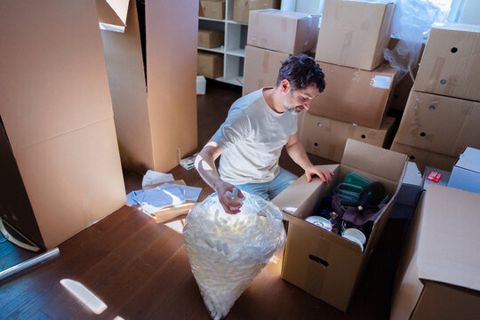 Man Packing Boxes During Home Move Into New Apartment