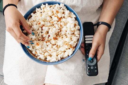 Top View of Hands with Popcorn and Remote Control