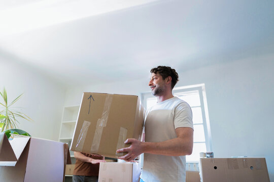 Man Carrying Boxes Into New Home During Move