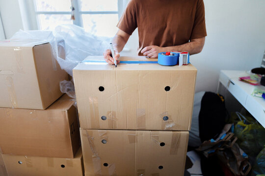 Person Labeling Moving Boxes During Home Move