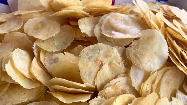 Close-up view of raw dry emping melinjo crackers. High angle close-up shot of uncooked Indonesian emping chips ready for frying.