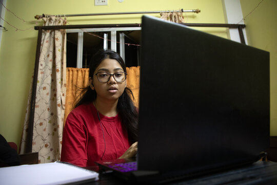 Young Indian woman doing study inside home