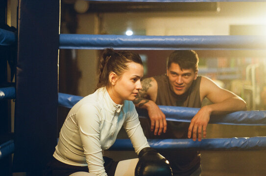 Happy trainer supports woman in ring during the break. Woman Power