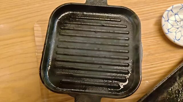 Small empty shichirin cast iron grill for barbecue, Japanese Food Preparation, Cast Iron Kitchen Equipment, Slow Motion, Overhead Shot