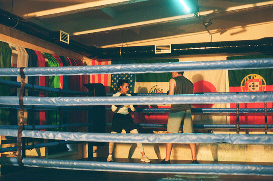 Boxer woman during workout with coach in boxing ring
