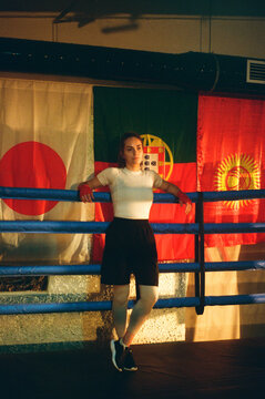 Woman boxer leans on fighting ring ropes. Woman Power
