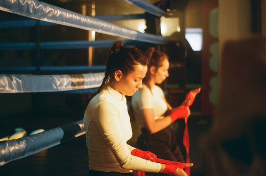 Women boxers unwrap hands with bandage in gym. Woman Power