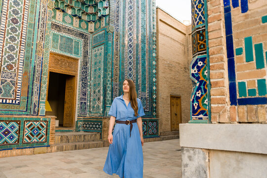 Woman Walks in Historic Area With Colorful Tile Work in Uzbekistan