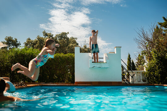Children jumping into swimming pool