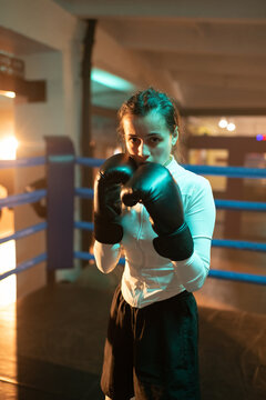 Female boxer blocks face with hands in ring during fight. Woman Power