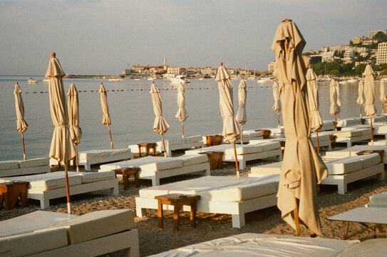 Sun Loungers and Parasols at a Beach Near a Coastal Town, Budva.
