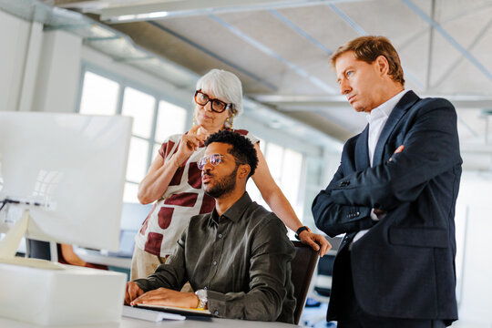 Business professionals analyzing data on computer in office