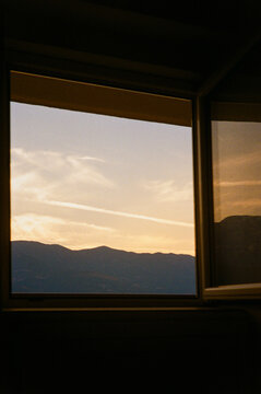 View From a Window Showing Mountains and Sky at Sunset