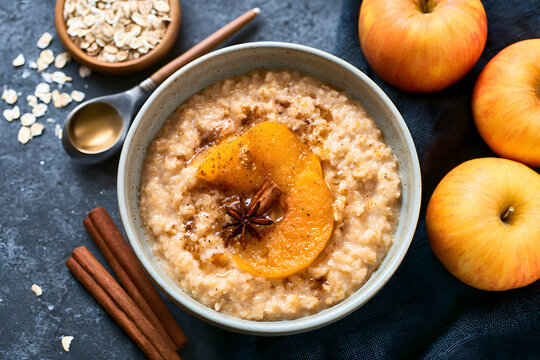 A flavorful autumn breakfast of oatmeal porridge topped with baked apple and cinnamon, enjoyed in a bowl