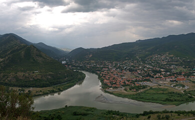 Panoramic aerial view of Mtskheta town and the confluence of Mtkvari and Aragvi rivers surrounded by mountains in Georgia © MikhailT