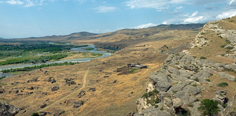 Panoramic view of Mtkvari River winding through dry steppe valley near Uplistsikhe ancient complex in Georgia © MikhailT