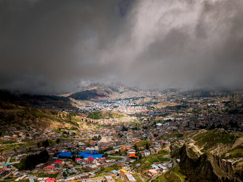 Aerial view of the dramatic rock formations of Valle De Las Animas with the urban landscape of La Paz nestled in the valley under heavy clouds in La Paz, Bolivia.