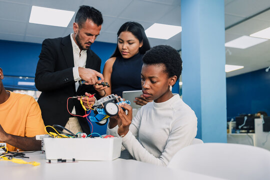 african american young university woman student working on a robotics project and car robotics in classroom. black girl in technology class in an Academic Environment in Latin America