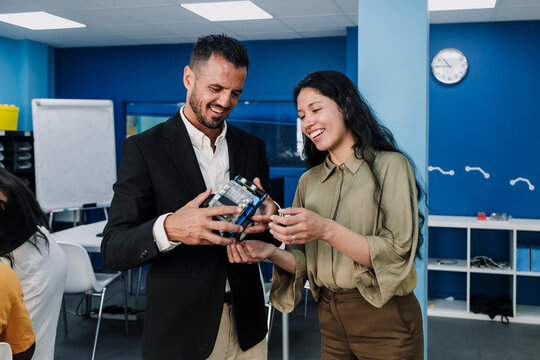 Young Latina college student and Hispanic professor working on a robotics and automotive robotics project in the classroom. Multicultural Latin people in a technology class in an academic setting in L