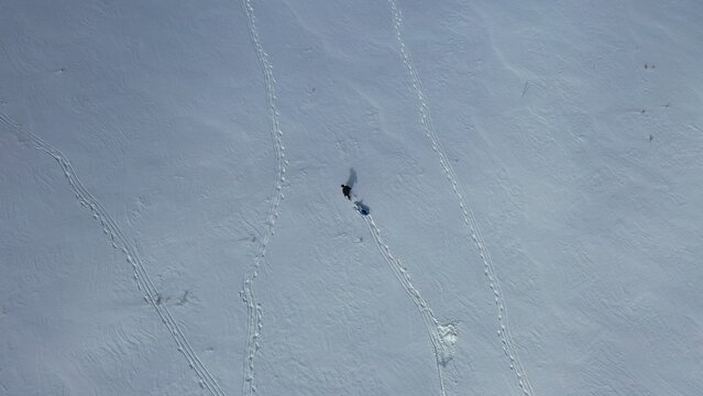 Aerial view of a person walking across a vast, snow-covered landscape in Derbent, Konya, Turkiye.