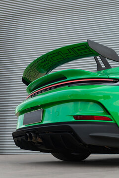 Green Porsche 911 GT3 rear end low angle view, Luxury sports car wing and tail lights outdoor