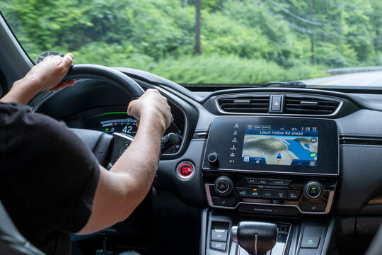 Person driving car with navigation system screen on dashboard