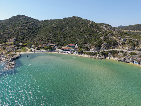 Aerial view of Sykias Beach featuring turquoise waters, sandy shoreline, and surrounding rocky hills in Paralia Sikias, Greece.