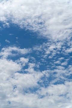 Blue sky with scattered white clouds background
