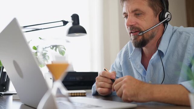 Stressed businessman speaking loudly during a work call while wearing a headset. Workplace pressure, business communication, emotional stress and professional challenges concept.