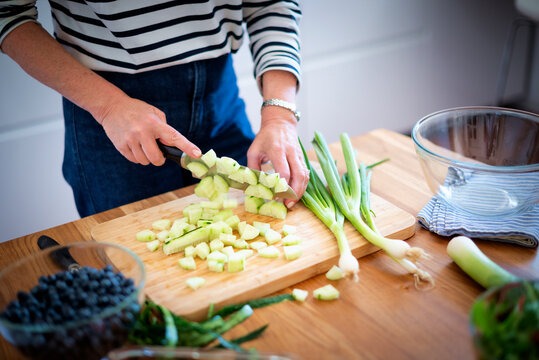 
Close up of woman's hands slicing fresh organic carrots on kitchen counter