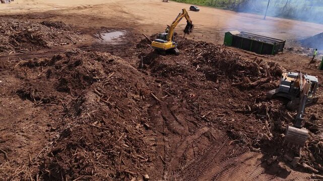 Tinian, Northern Mariana Islands - 26 June 2026: Aerial view of excavators clearing debris and wood chips at a construction site.