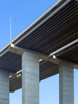 View of the massive concrete pillars and underside of a bridge structure against a clear blue sky in Istanbul, Istanbul, Turkiye.