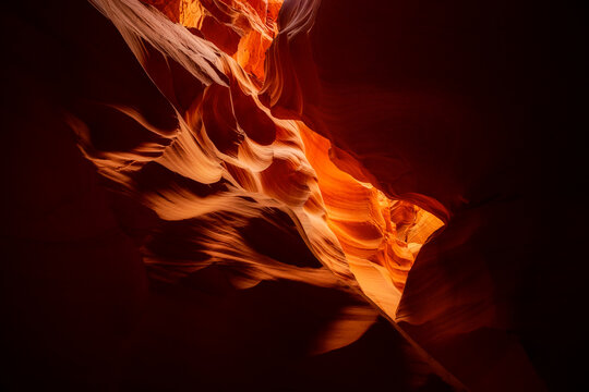 View of Antelope Canyon featuring smooth, flowing sandstone walls carved by water and wind, illuminated by soft, warm light in Coconino County, Arizona, United States.