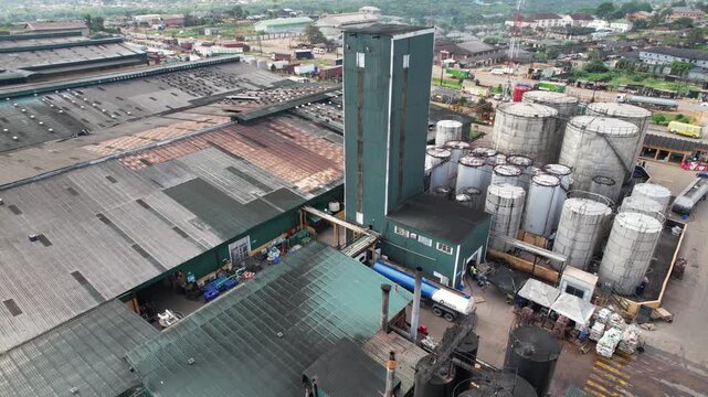 Aerial view of the IDL factory featuring a tall green tower, industrial storage tanks, and factory buildings in Ota, Ogun State, Nigeria.