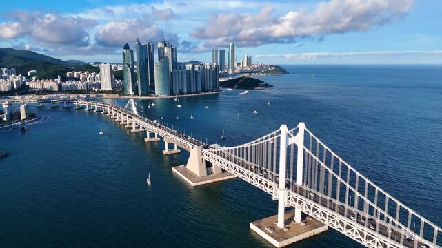 Aerial view of the iconic Gwangan Bridge spanning the bay with the modern skyscrapers of the Busan skyline in the background, Busan, Busan, South Korea.