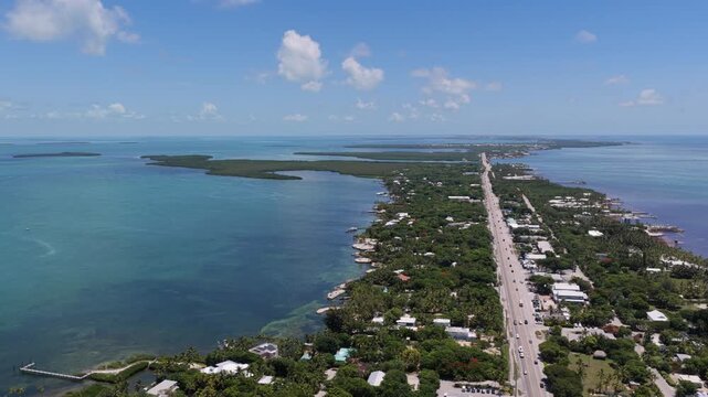 Aerial view of the Overseas Highway stretching along the lush green islands of Islamorada surrounded by turquoise ocean waters in Islamorada, Florida, United States.