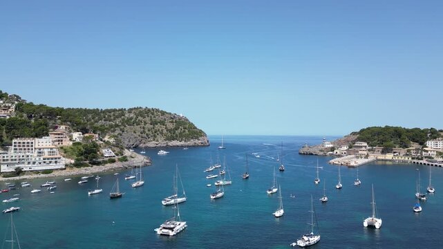 Aerial view of sailboats and yachts anchored in the turquoise waters of the bay at Port de Soller, Balearic Islands, Spain.
