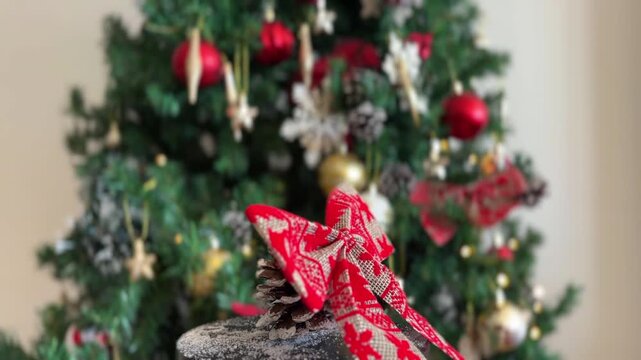 Lazo navide&ntilde;o girando con &aacute;rbol desenfocado