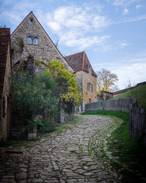 View of the historic stone buildings and cobblestone street in Beynac-et-Cazenac, Nouvelle-Aquitaine, France.