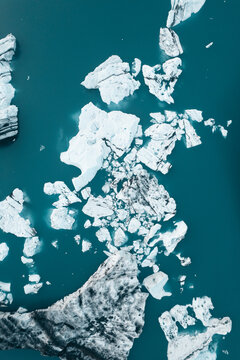 Aerial view of Jokulsarlon glacier lagoon with floating icebergs and chunks of ice drifting in the deep blue water in Sveitarfelagid Hornafjordur, Iceland.