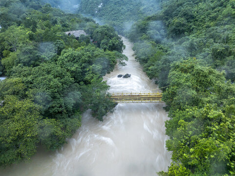 Aerial view of the Cahabon River at Semuc Champey, with a yellow suspension bridge crossing the turbulent water in San Agustin Lanquin, Alta Verapaz Department, Guatemala.