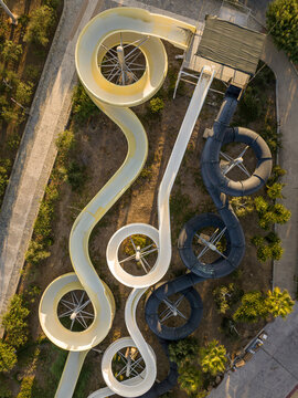 Aerial view of water slides in a water park surrounded by trees and paths in Kos, Greece.