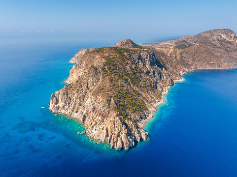 Aerial view of the rocky coastline of Kos, featuring steep cliffs, sparse vegetation, and vibrant turquoise waters surrounding the island in the Aegean Sea, Kos, Greece.