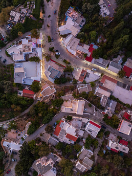 Aerial view of Zia with white buildings, narrow streets, and lush greenery in the town of Kos, Greece.