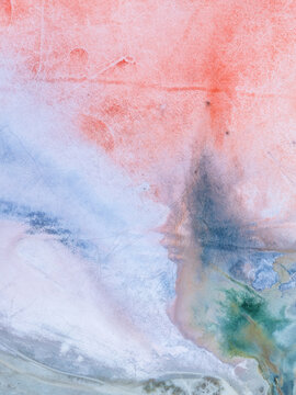 Aerial view of the colorful salt lake with vibrant pink, blue, and green mineral deposits and textured salt crusts in Kos, Greece.