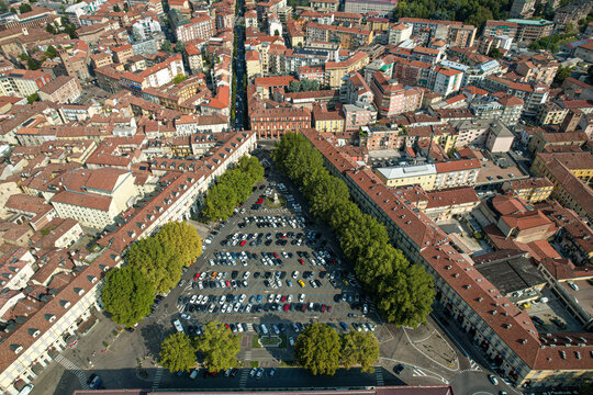 Aerial view of Piazza Campo del Palio with parked cars and surrounding historic buildings in the city center of Asti, Piedmont, Italy.